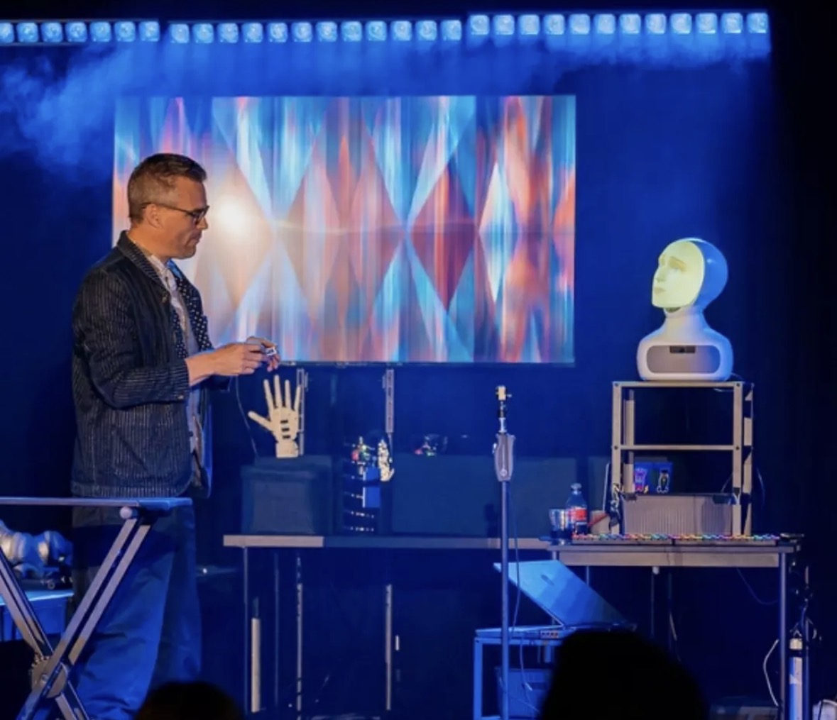 Charlie Caper on stage with AI robot and custom automatons — where magic meets technology